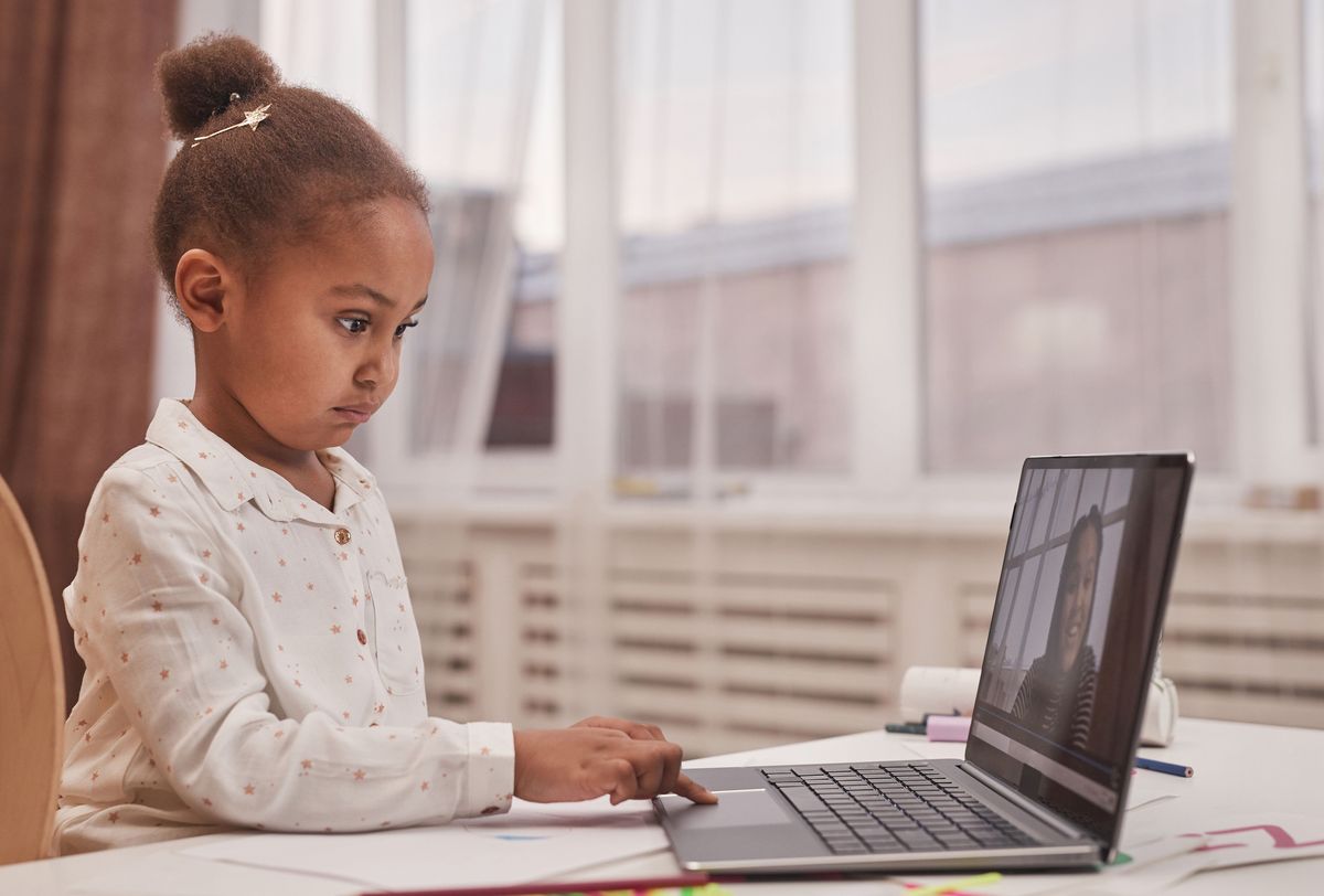 Young child joining an online lesson on a laptop at home