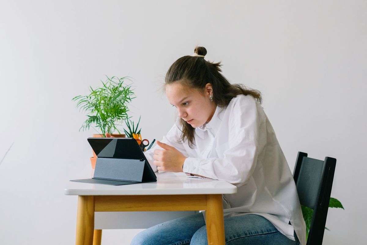 Secondary pupil studying at a desk with a tablet