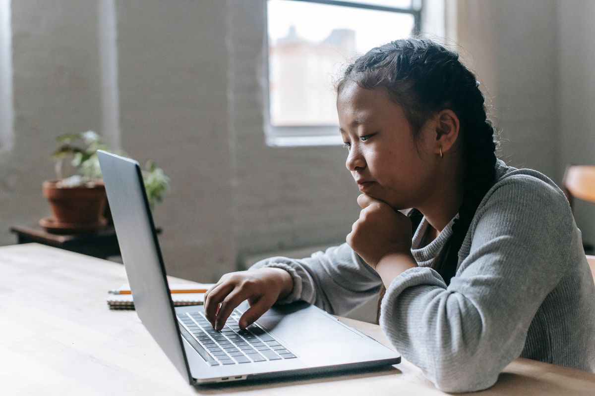 Pupil concentrating on an online lesson on a laptop